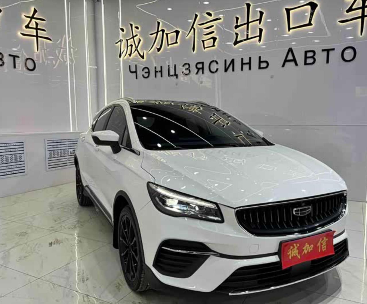 Белый Geely Emgrand S в шоуруме китайского экспортёра, на стене вывеска «Чэнцзясинь АВТО»