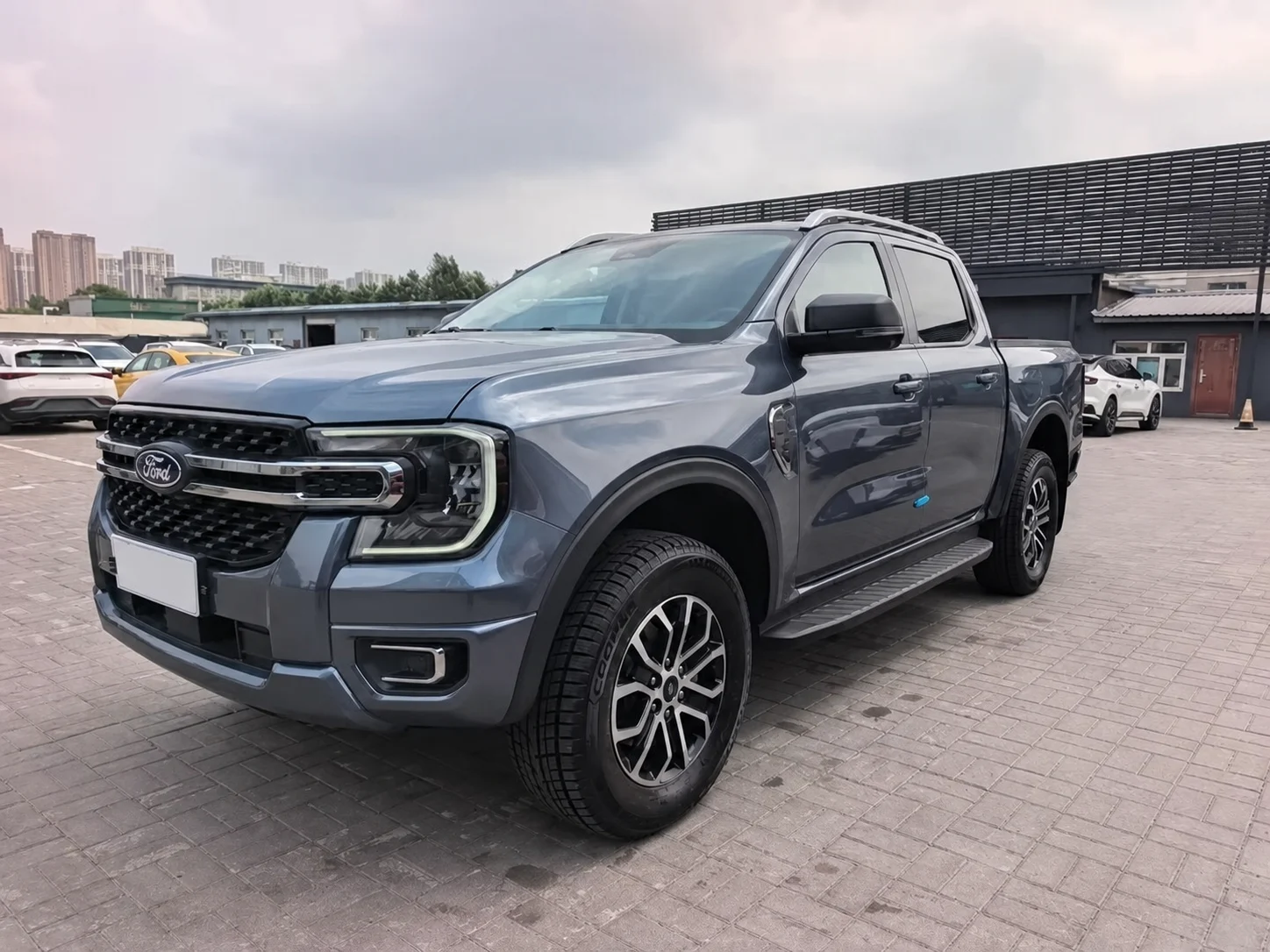 Тот же пикап спереди слева на площадке: решётка с эмблемой Ford, светодиодные фары и легкосплавные диски